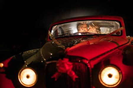 Winter Wedding Photography-55 A bride and groom in a vintage car at night captured by a skilled winter wedding photographer.