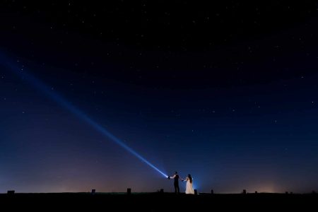 Winter Wedding Photography-24 A couple, Wedding Photographers, holding hands and holding a flashlight.