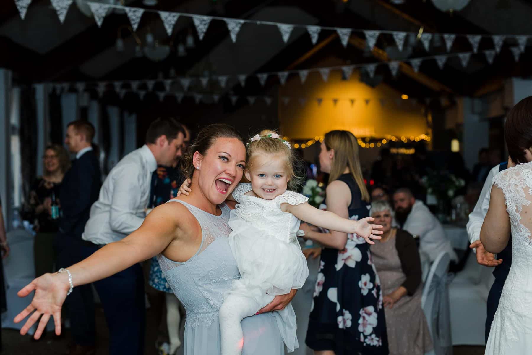 Bridesmaid dancing with flower girl on the dance floor