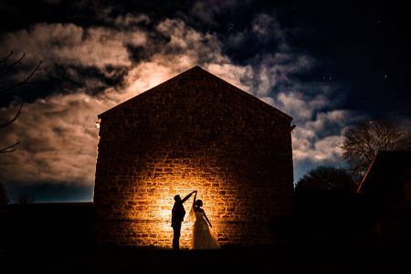 Best of Sky Photography 2021-13 Wedding Photographers capturing a bride and groom in front of a building at night under the stunning Northampton sky.