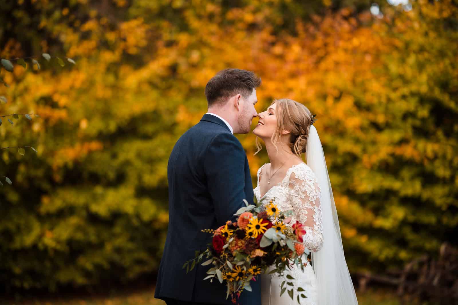 Couple kissing in autumnal colours at Dodford manor