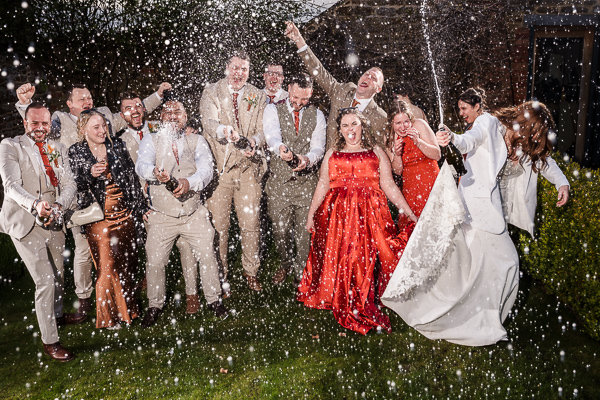 wedding photography portfolio 72 Group celebrating with champagne outdoors at a wedding.
