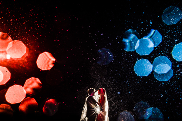 winter low light wedding photographer 13 A couple faces each other under a shower of lights, with red and blue bokeh effects creating a magical scene. Captured by an expert wedding photographer in Oxford, this winter moment is beautifully framed despite the low light ambiance.