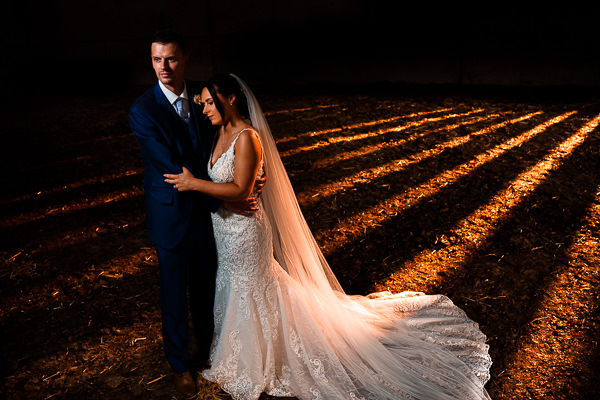 winter low light wedding photographer 16 Bride and groom embracing, illuminated by a spotlight with dramatic shadows on the ground.