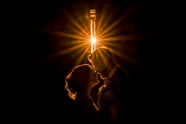 winter low light wedding photographer 30 Silhouette of couple kissing under bright light.