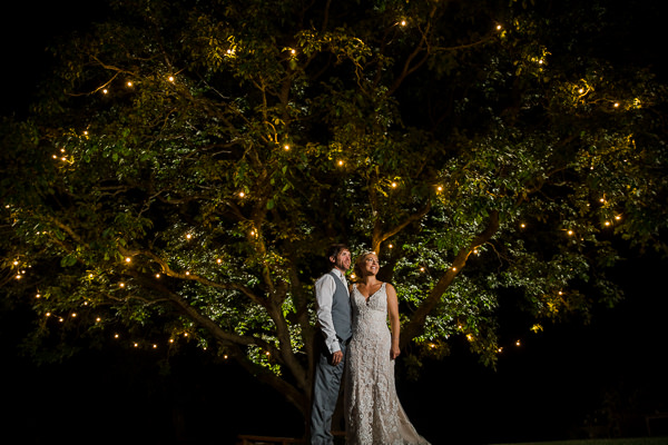 winter low light wedding photographer 5 Bride and groom under illuminated tree at night