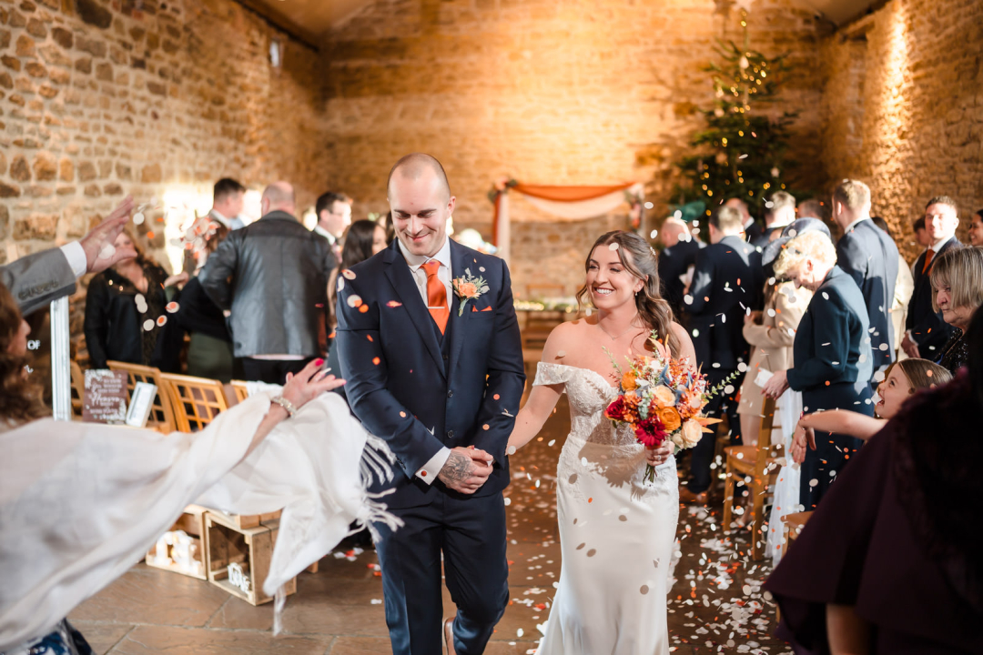 Bride and groom celebrating wedding ceremony indoors.