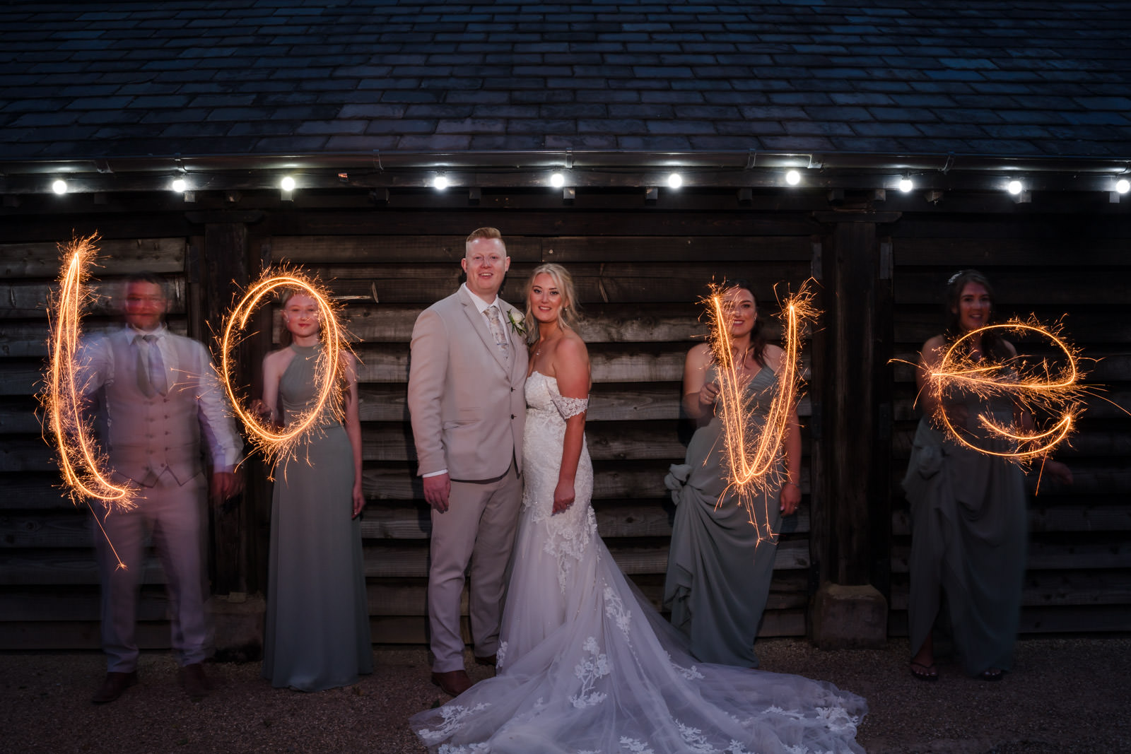Wedding couple with sparklers spelling 'love'.